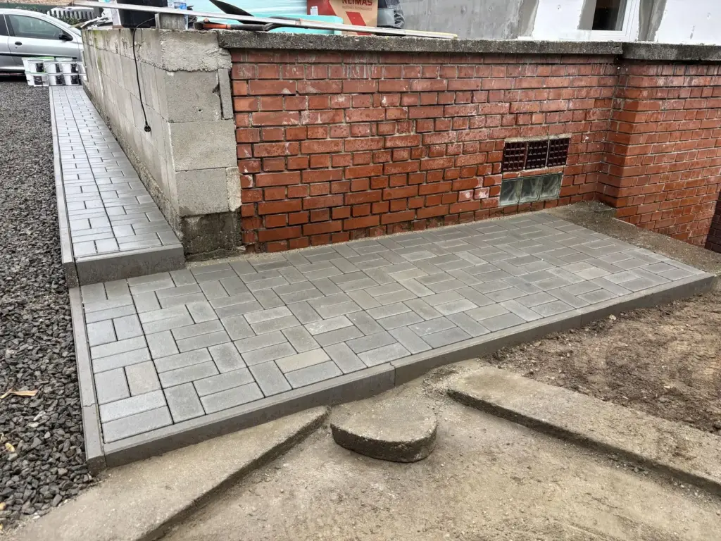 Süllyesztett terasz térkövezése téglafal mellett
